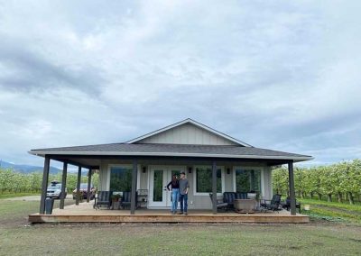 Farmhouse owners at side of completed exterior