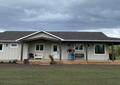 Farmhouse owners in front of completed exterior