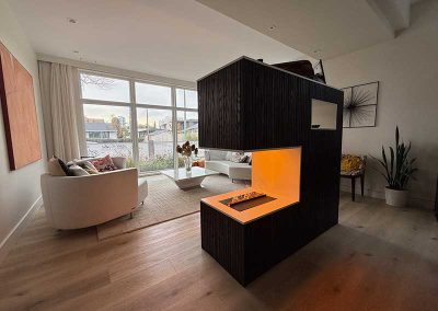 North end custom millwork with electric fireplace acts as divider between living room and dining room