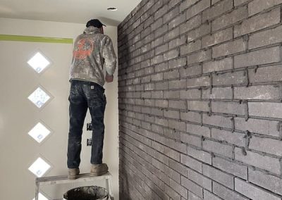 North End installing interior grey brick wall in foyer